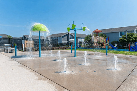 A playground with a water feature in the foreground.