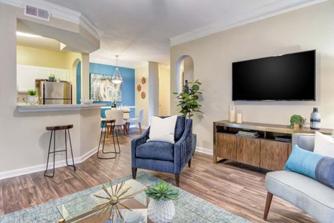 A living room with a blue chair and a black TV.