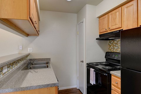 A kitchen with black appliances and wooden cabinets.