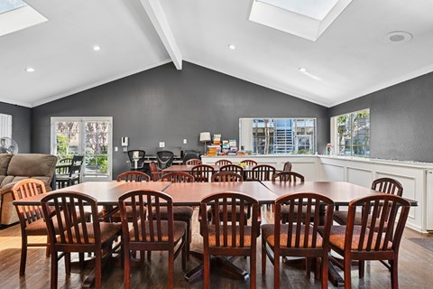 A dining room with a large table and chairs.