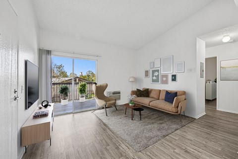 Bright living room with wood-style floors at Sunnyside Senior Apartments in San Dimas, CA