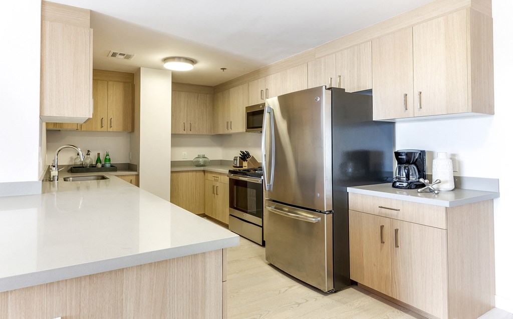 a kitchen with white countertops and wooden cabinets