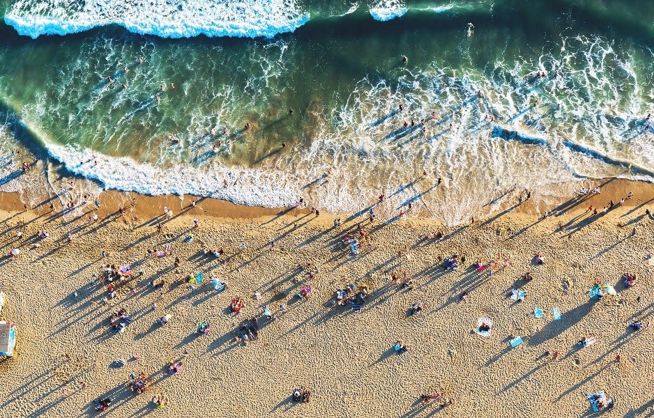 a beach with people and surfboards on the sand