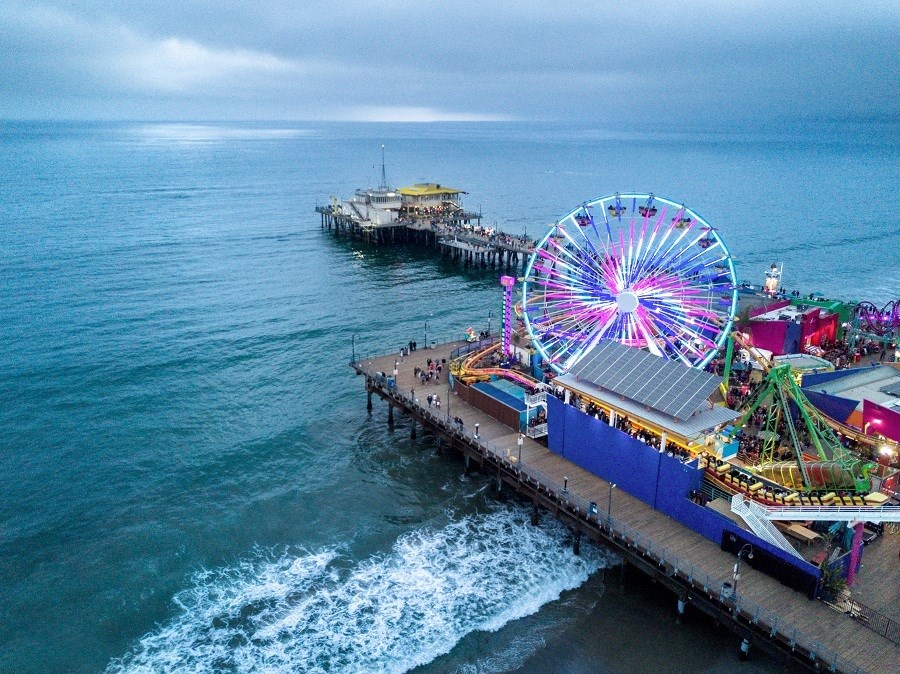 a ferris wheel on a pier with the ocean in the background