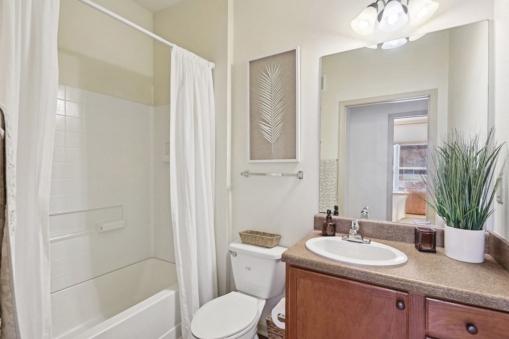 Modern bathroom featuring wood cabinetry and updated fixtures at Tattersall Village Apartments near Fort Stewart