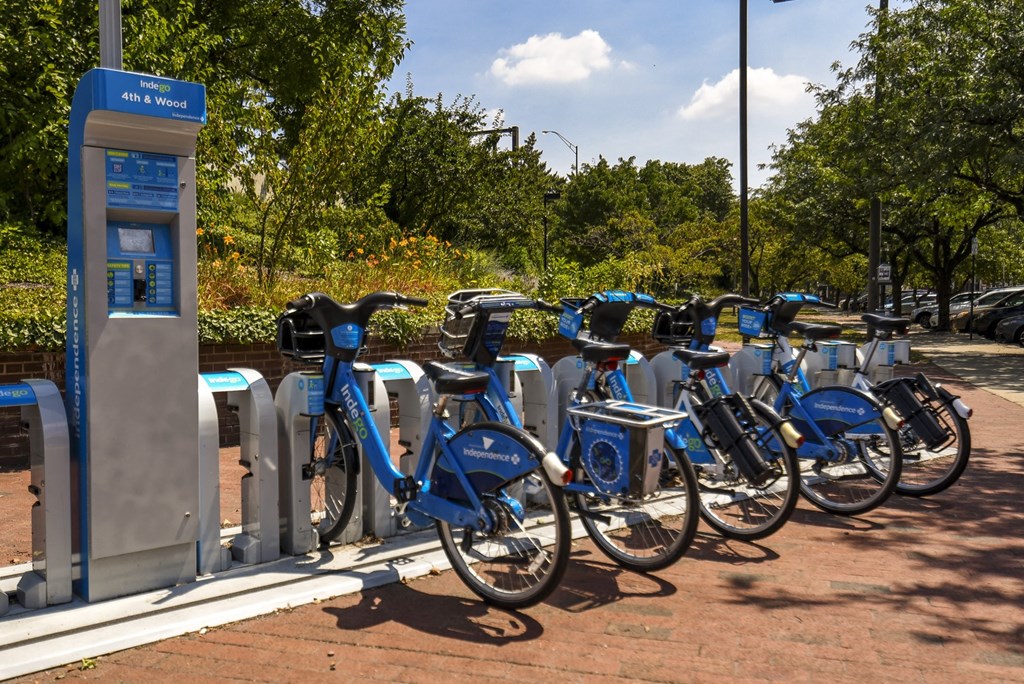a row of blue bikes parked next to a parking meter