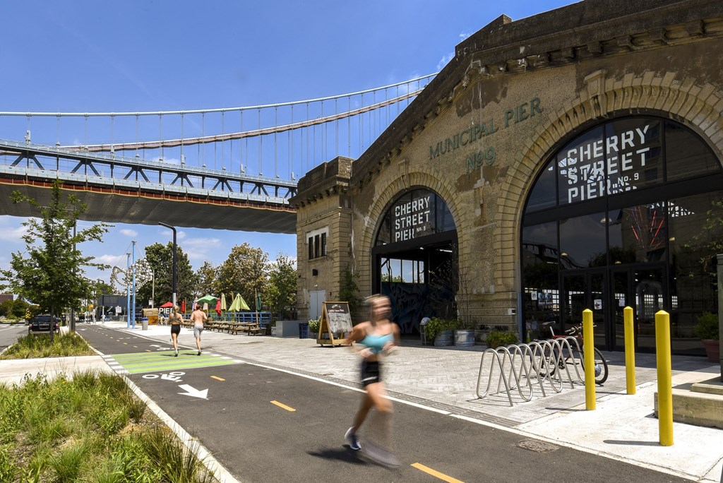 a runner passes the cherry street pier in philadelphia