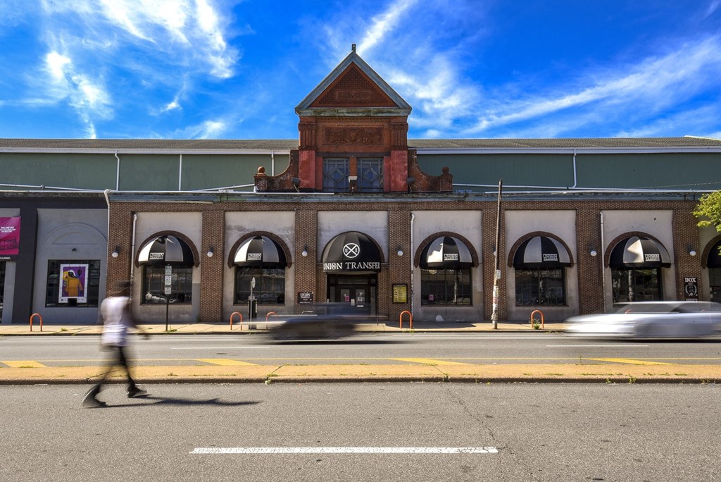 a man walking down a street in front of a building