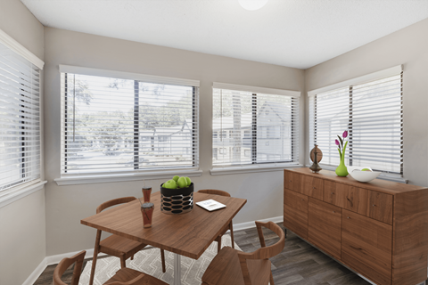 A dining room with a wooden table and chairs.