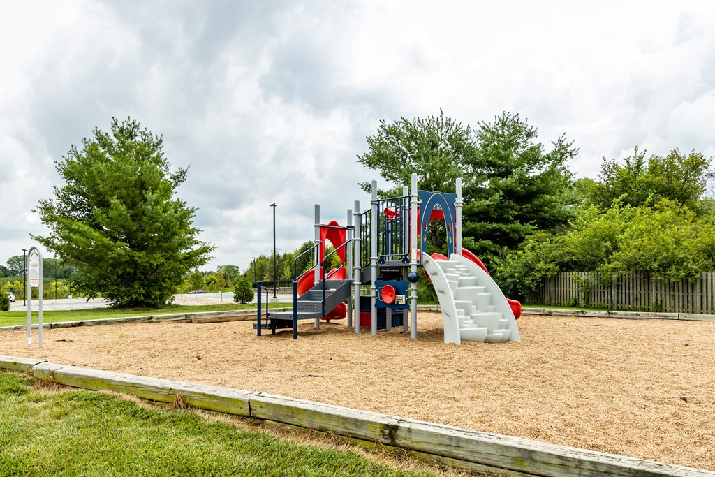 a playground with a slide and climbing equipment in a park