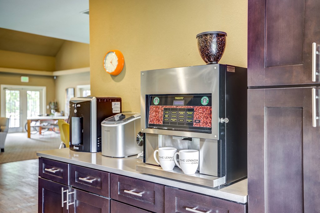 a coffee bar in a hotel room with a coffee machine and coffee cups on the counter