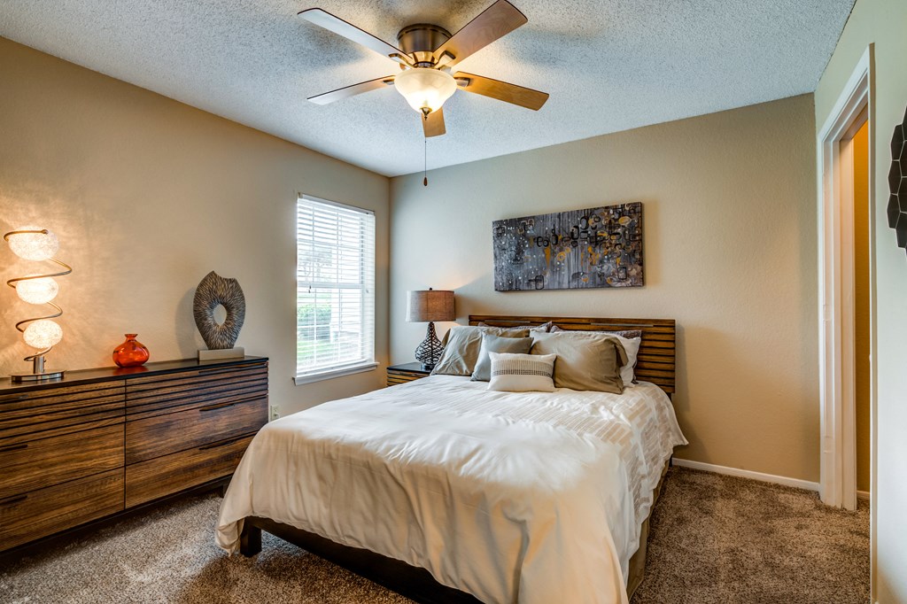 a bedroom with a large bed and a ceiling fan