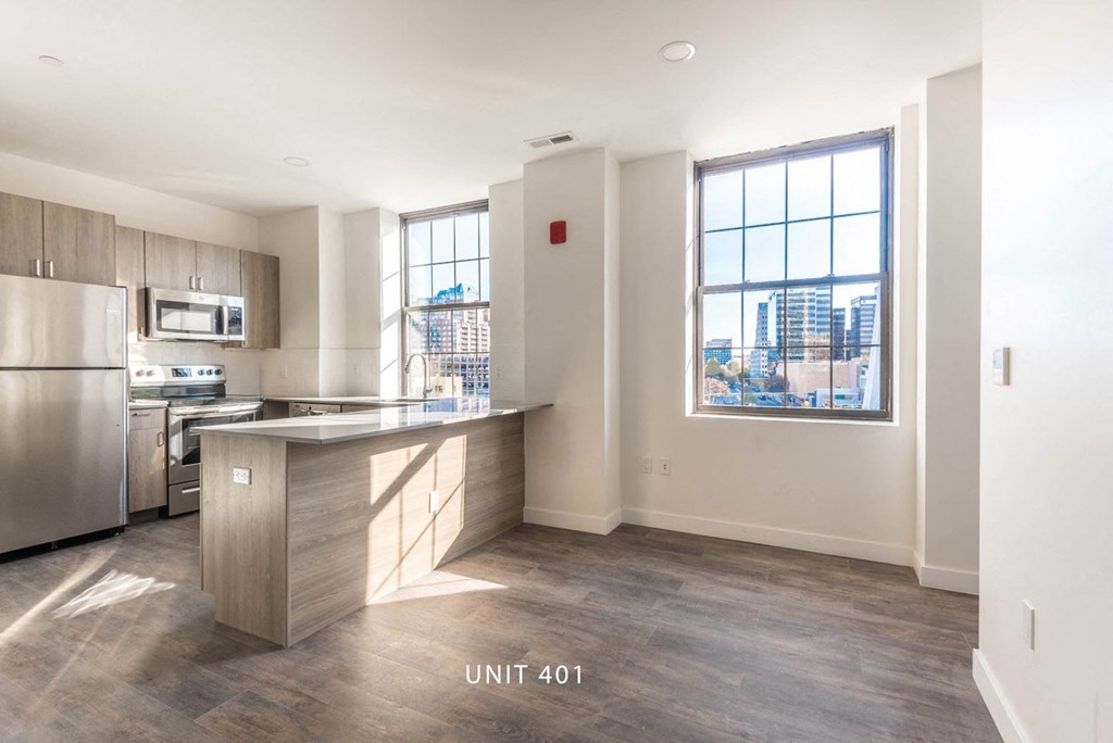 an empty kitchen with stainless steel appliances and a large window