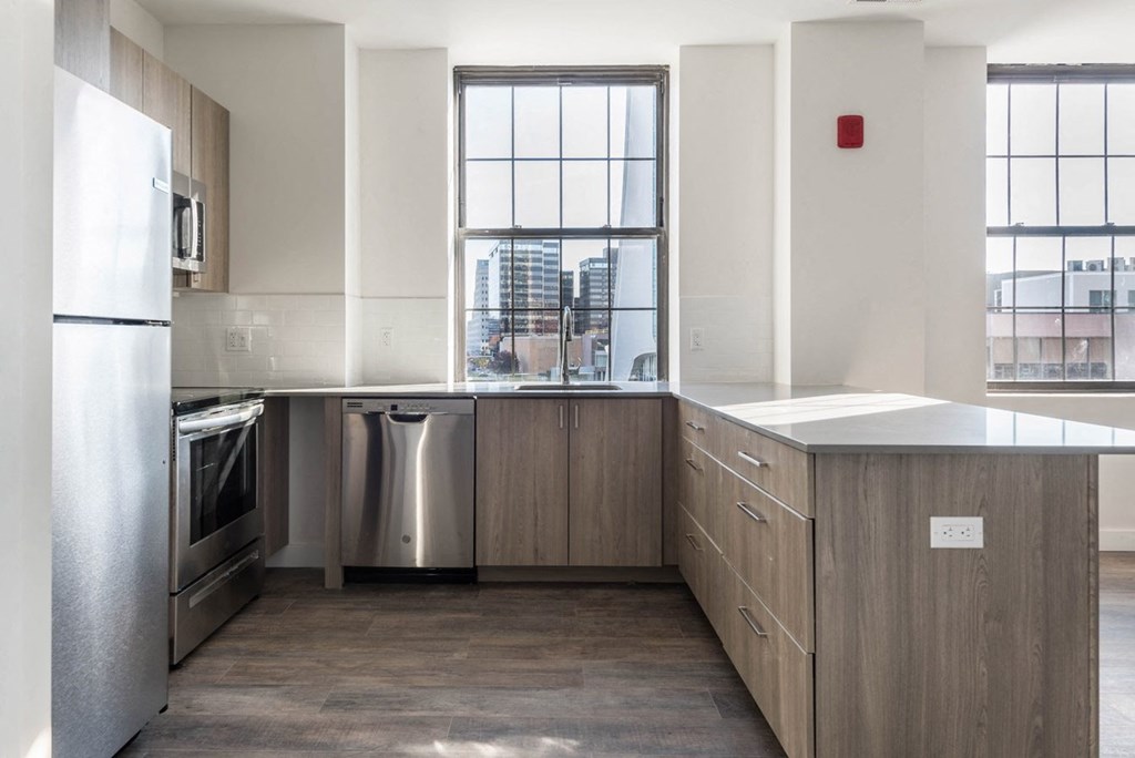 an empty kitchen with stainless steel appliances and a window