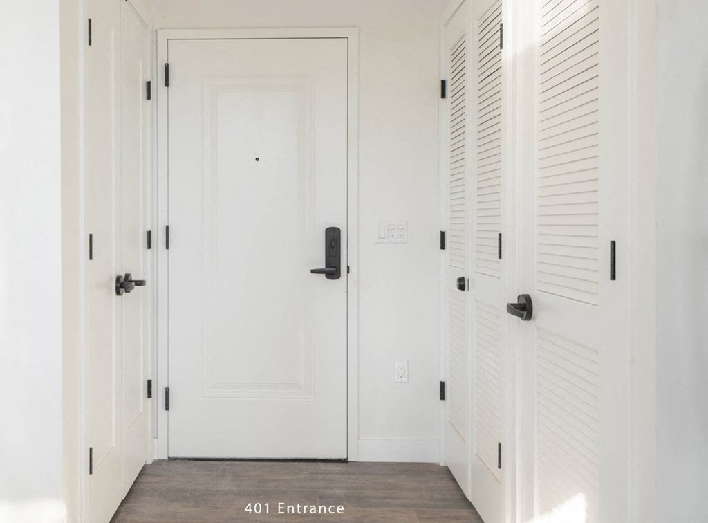 a hallway with white doors and white shuttered doors