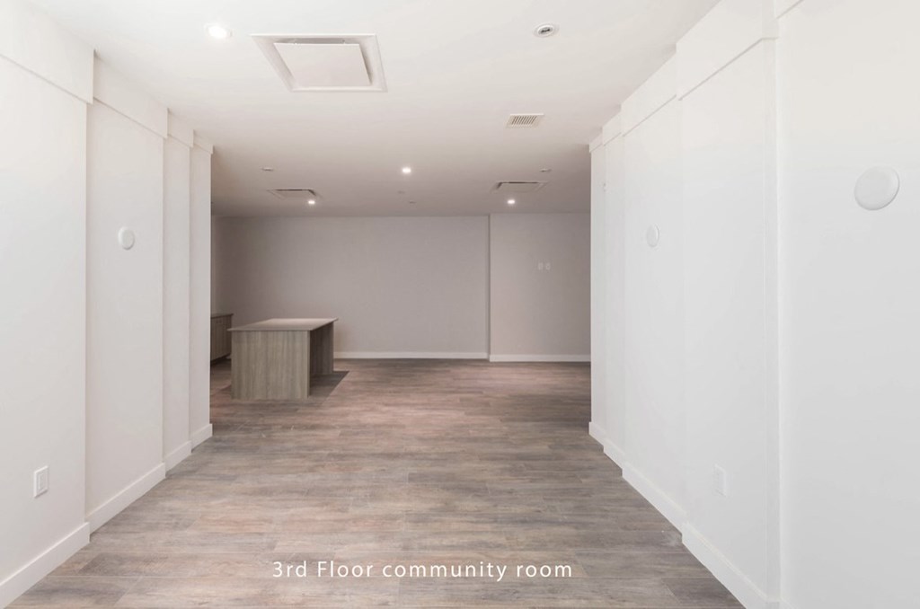 a large empty room with white walls and a wooden floor