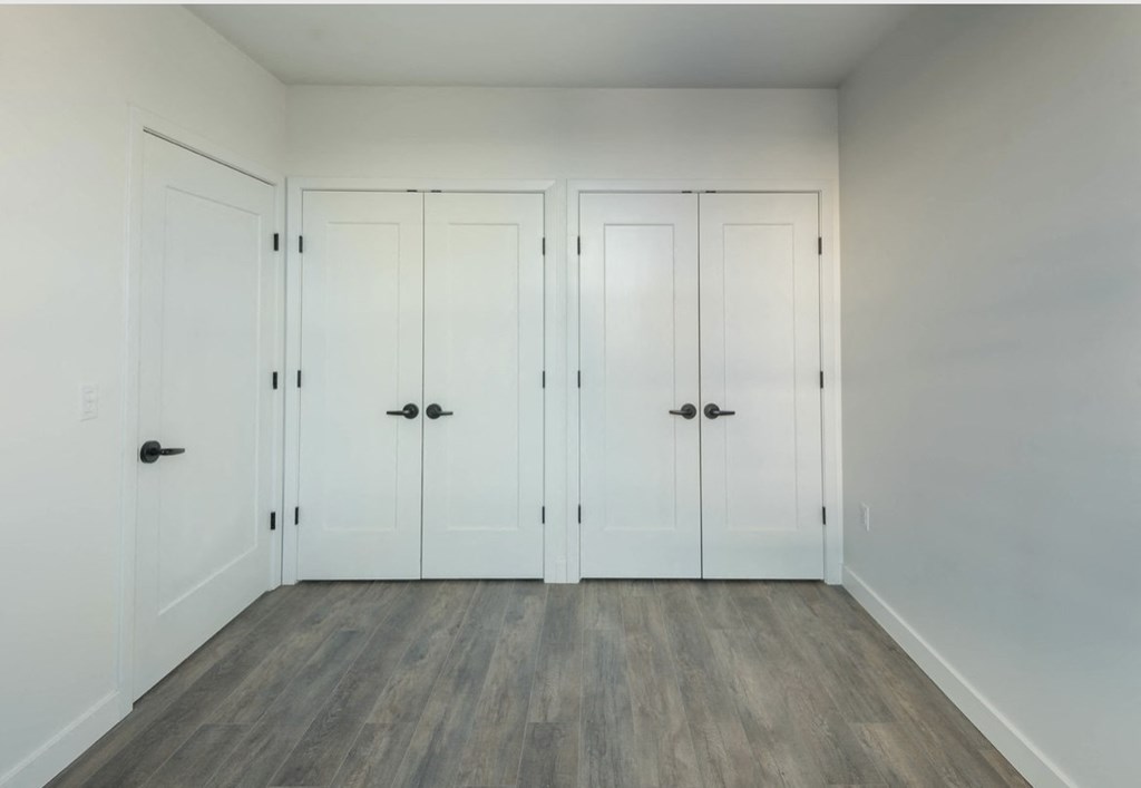 a row of white closets in a room with wood floors