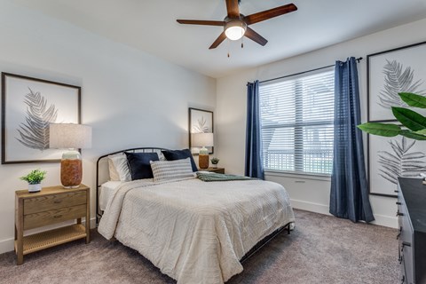 an empty bedroom with a bed and a ceiling fan