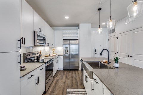 a large kitchen with white cabinets and stainless steel appliances