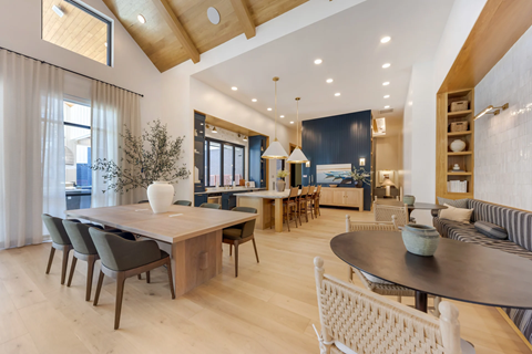 A modern dining room with a large table and chairs.