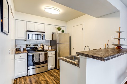 A kitchen with white cabinets and a black stove top.