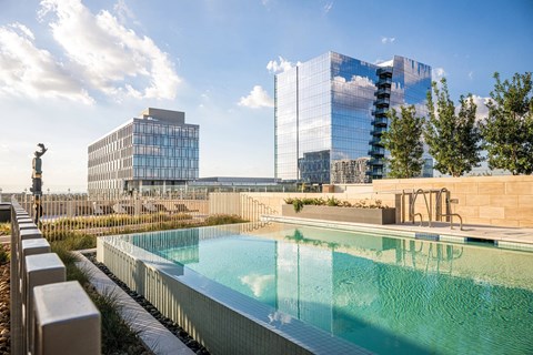 A swimming pool with a glass building in the background.