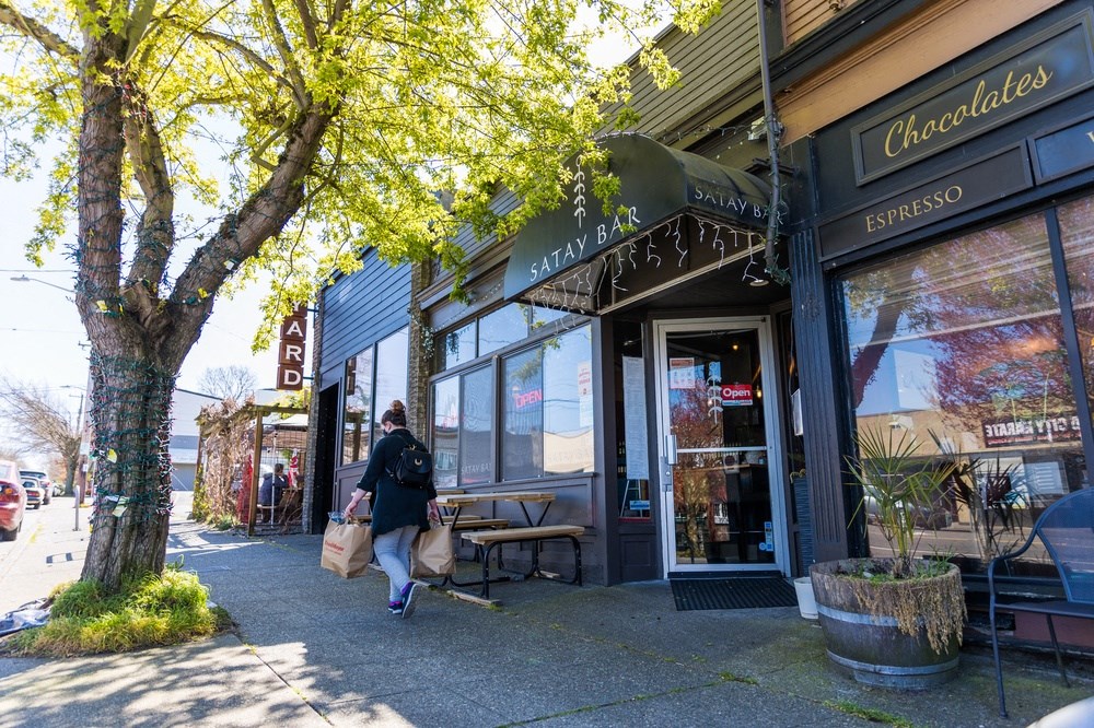 a person walking down a sidewalk in front of a store