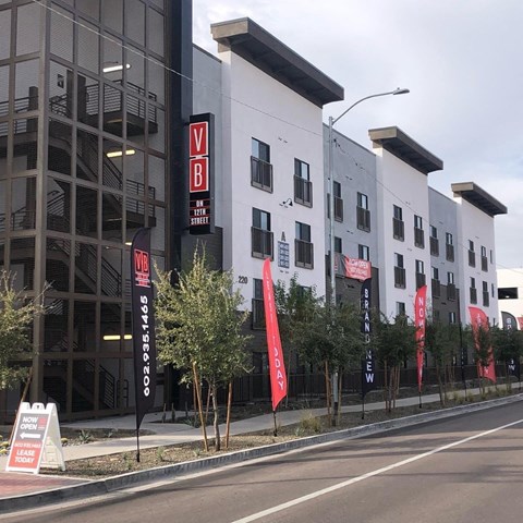 Downtown Phoenix, AZ, ASU Off-Campus Apartments - VB on 12th Street - Building Exterior With Street Level Signage, Modern Windows, Landscaped Sidewalk, And Multi-Story Apartment Facade.