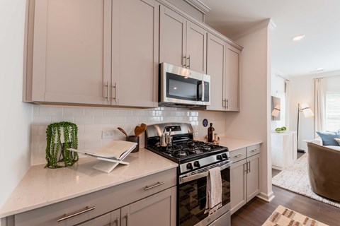 A modern kitchen with a stove top oven and microwave above it.