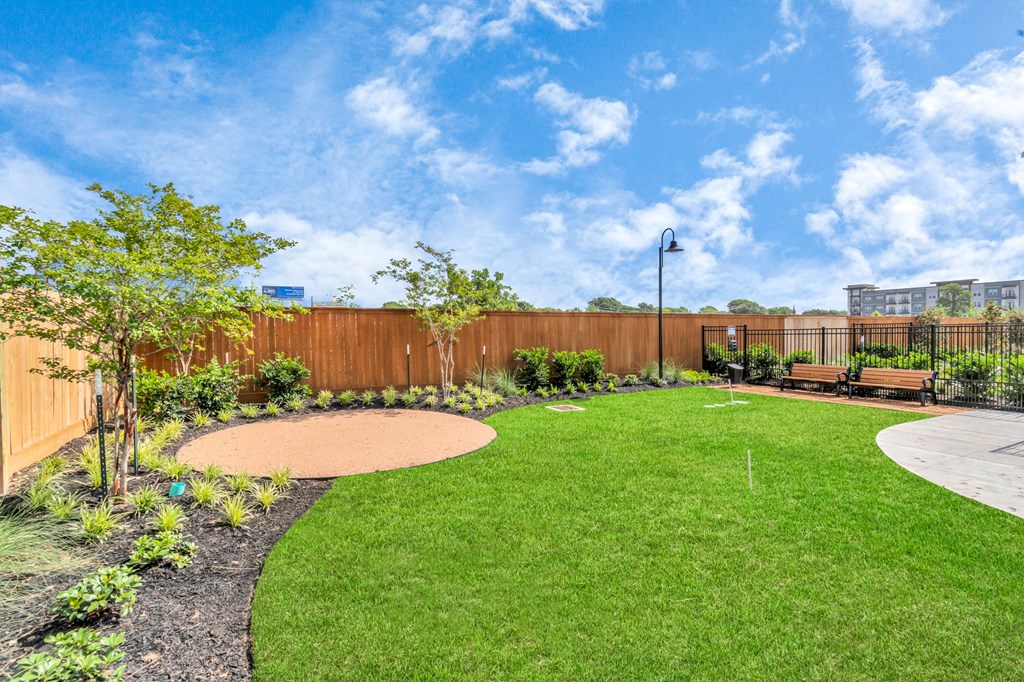 a backyard with green grass and a wooden fence