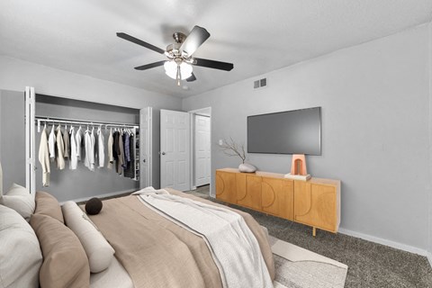 Pet-Friendly Apartments in Overland Park– Treetop Lodge – A bedroom with a bed, a TV, and a wardrobe.