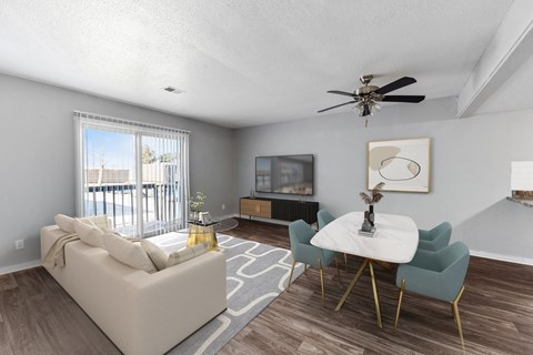 A living room with a white couch, a white coffee table, and a ceiling fan.