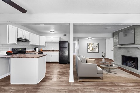 A modern kitchen with white cabinets and a black refrigerator.