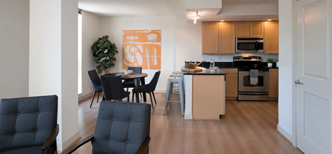 A kitchen with a table and chairs in front of it.