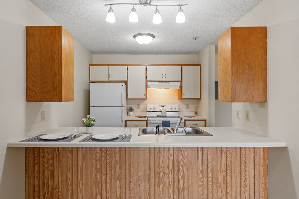 a kitchen with white appliances and wooden cabinets