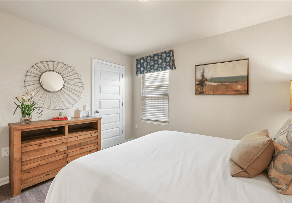 a bedroom with a bed and a dresser with a mirror