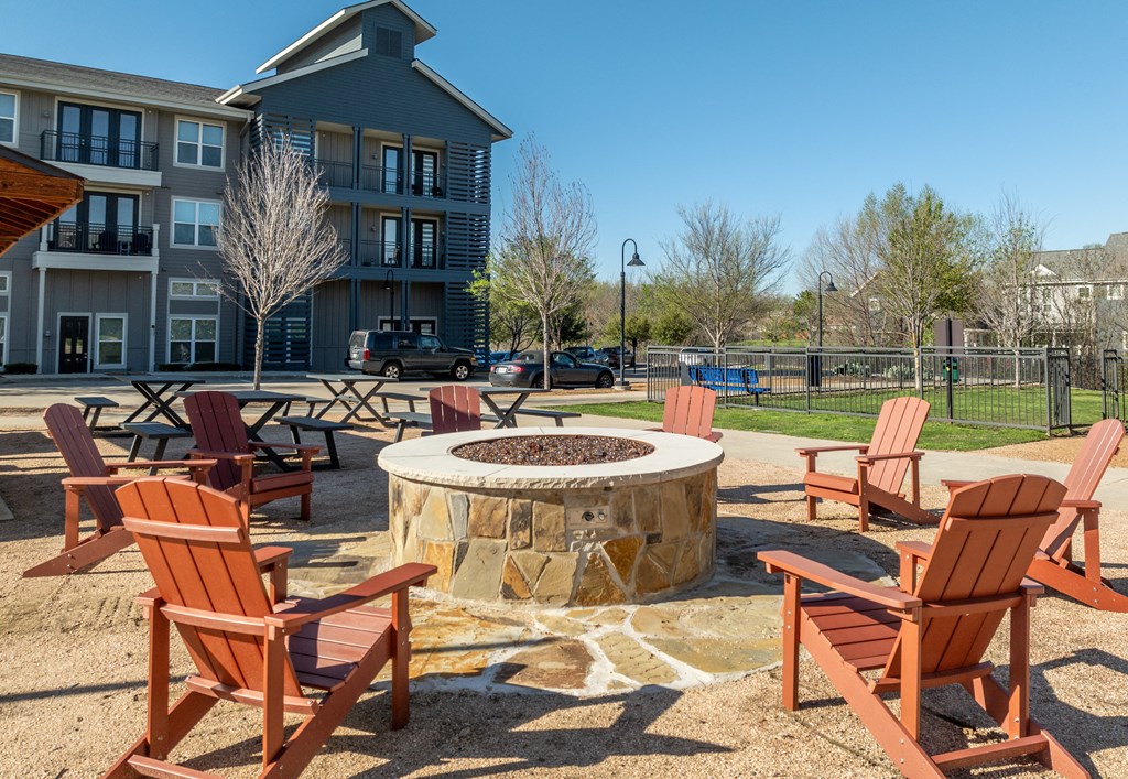 Apartments In Rowlett, TX - Village of Rowlett - Campstyle Fire Pit Surrounded By Adirondack Chairs