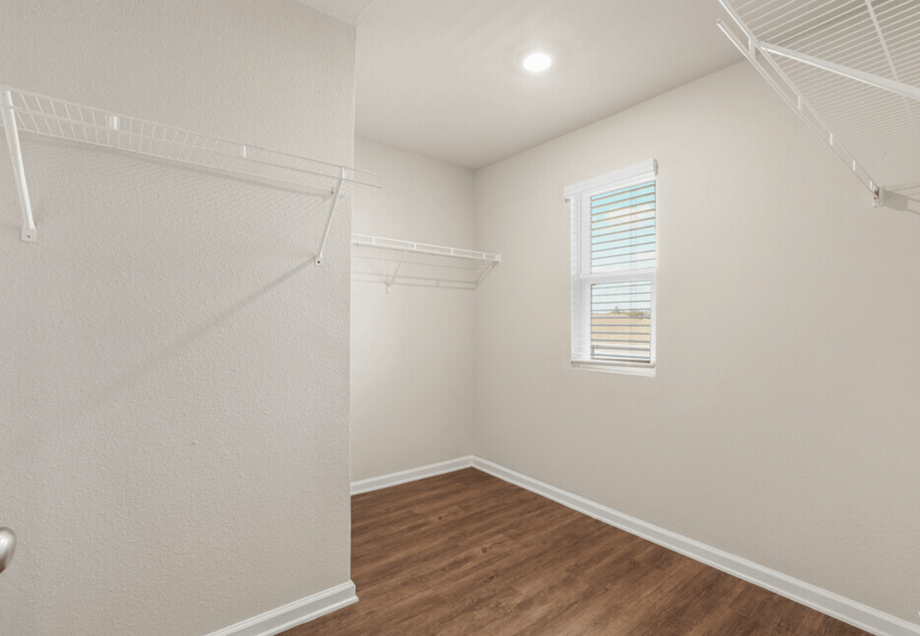 a bedroom with a closet and a window and a wooden floor