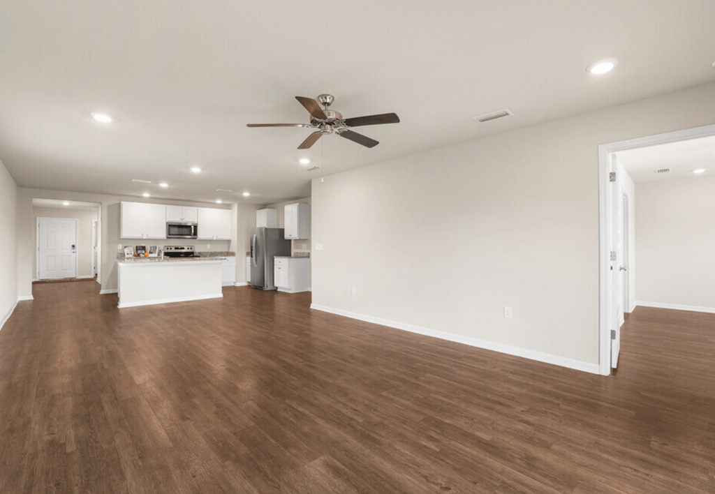 a living room with a ceiling fan and a kitchen