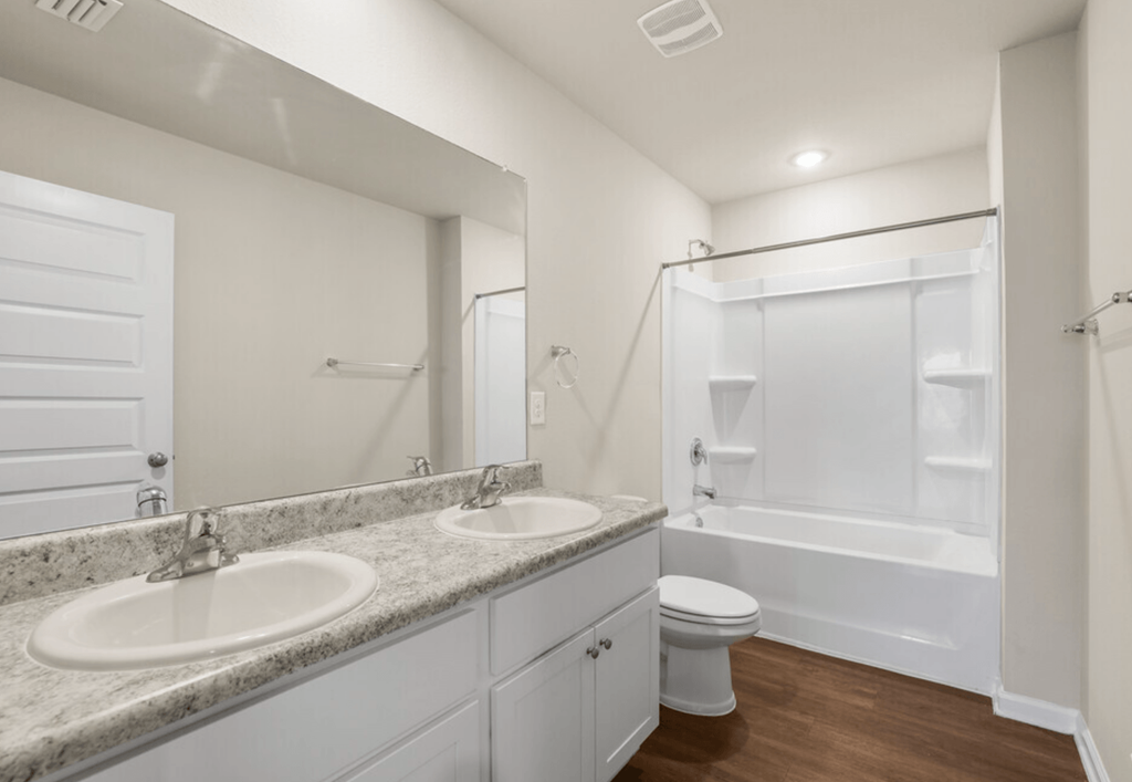 a bathroom with two sinks and a shower and a toilet