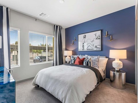 A bedroom with a large bed and a blue lamp.
