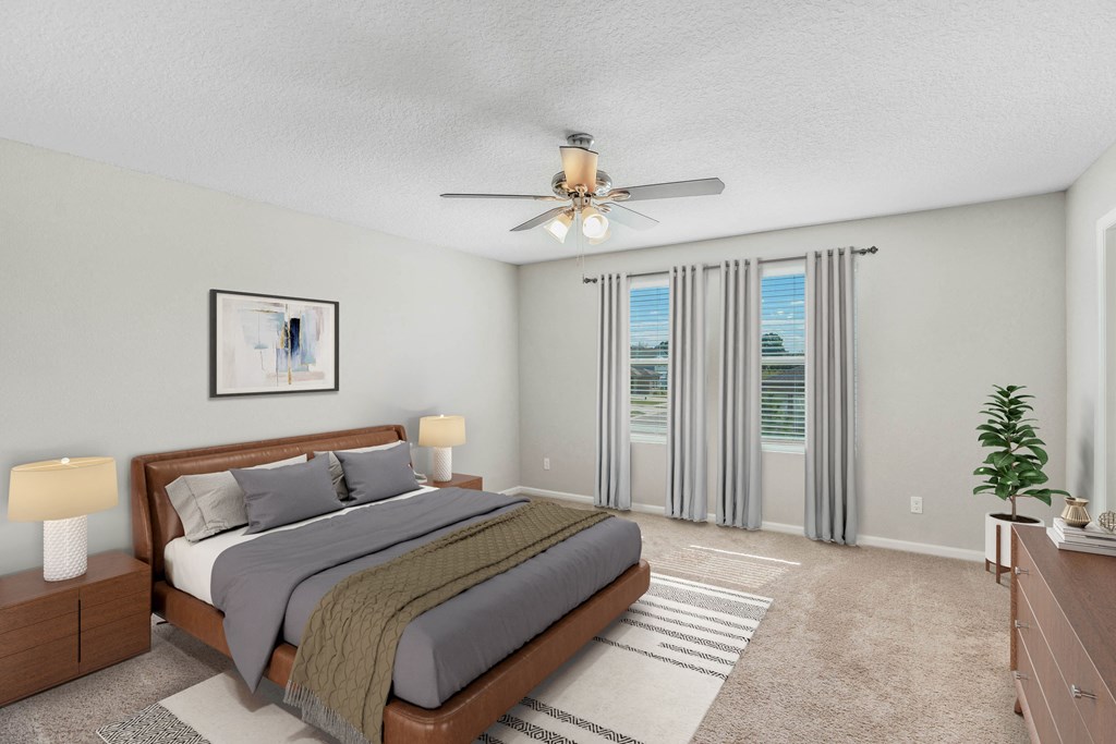 A bedroom with a large bed and a ceiling fan.