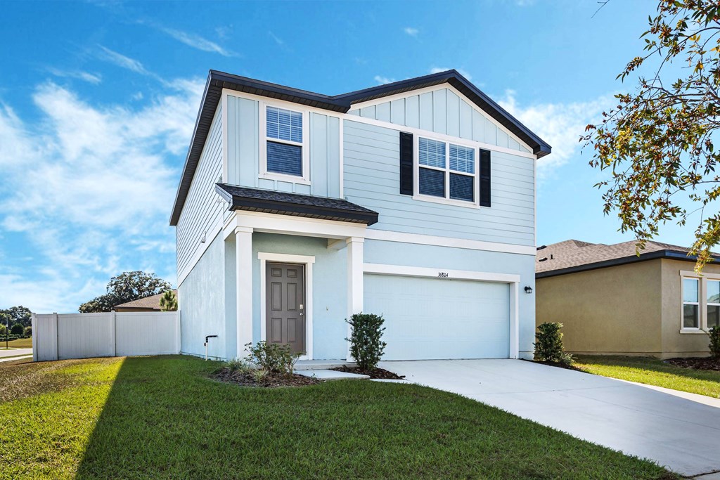 A two-story house with a white garage door.