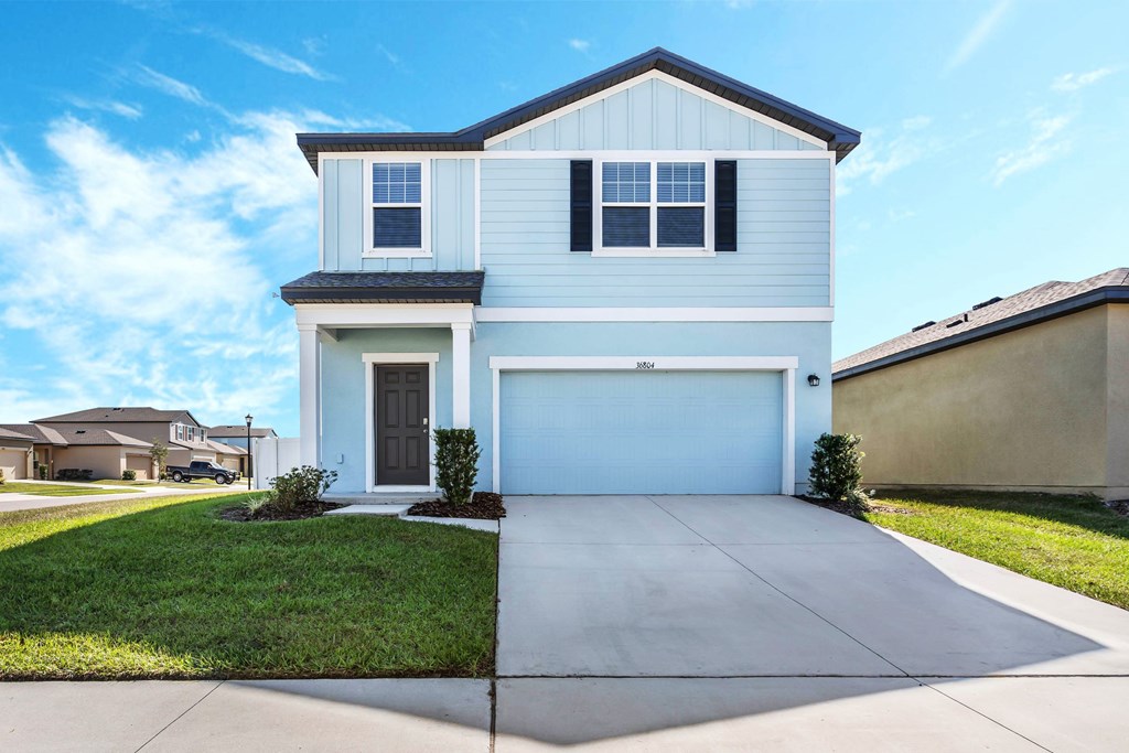 A two-story house with a garage and a driveway.