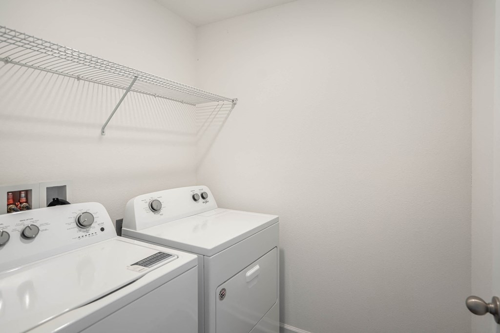 A white laundry room with a washer and dryer.