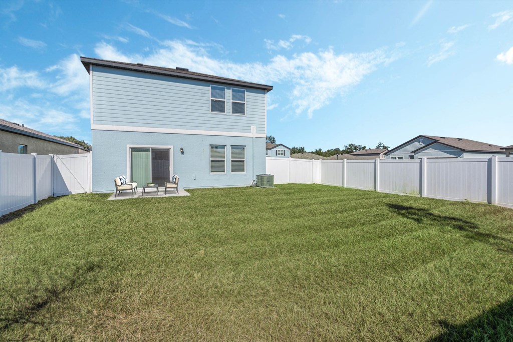 A house with a white fence and a green lawn.