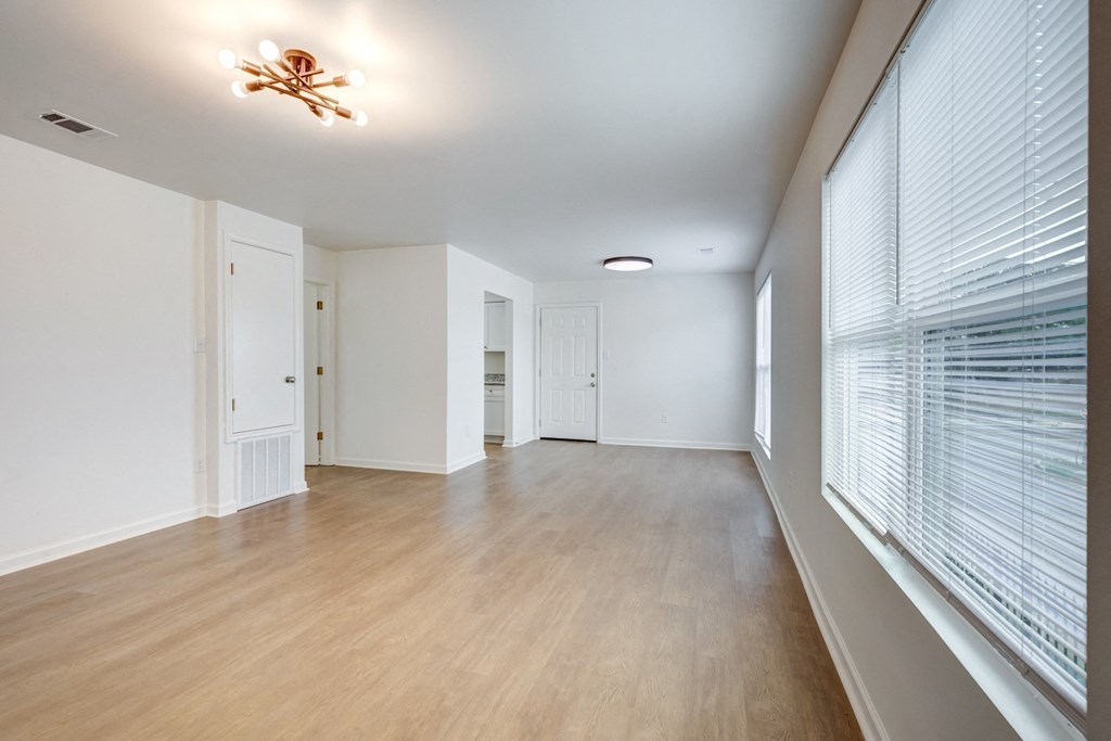 Whitney Manor Apartments in Gretna, LA photo of  an empty living room with a large window and wood flooring