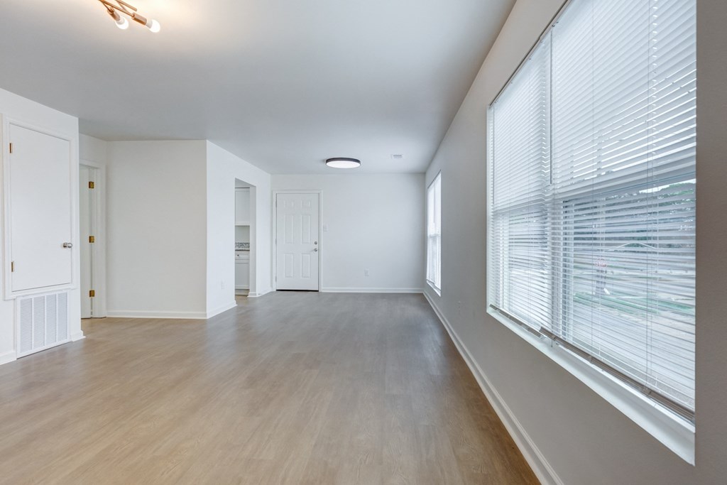 Whitney Manor Apartments in Gretna, LA photo of  an empty living room with a large window and wood flooring