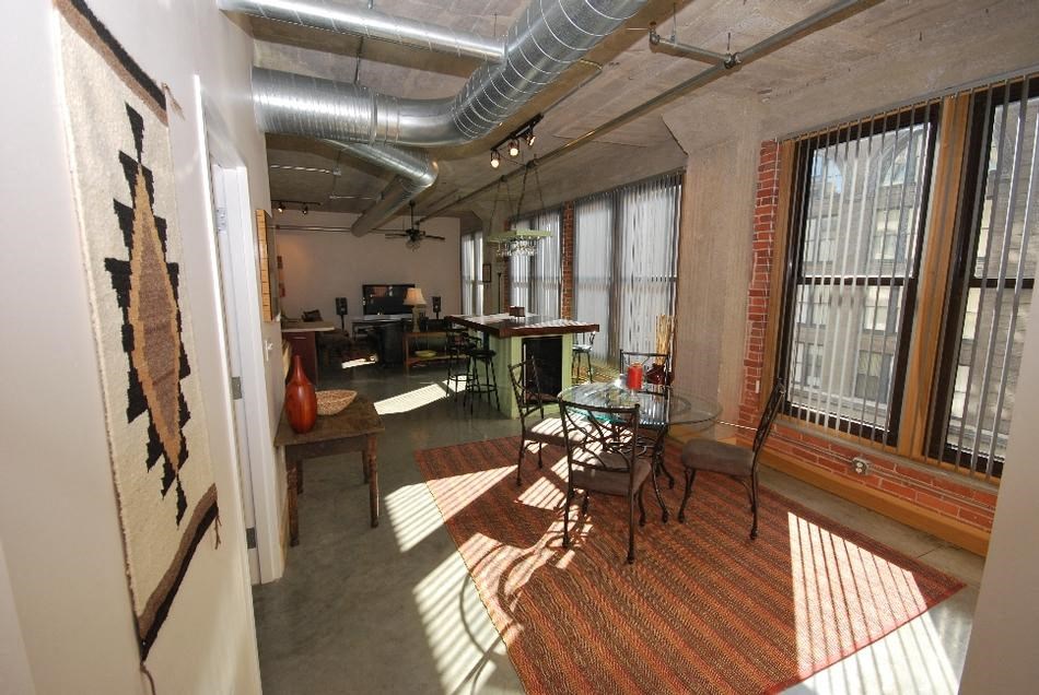 a room with a table and chairs and a large window