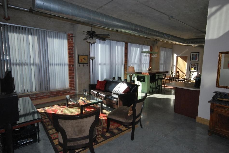 a living room filled with furniture and a ceiling fan